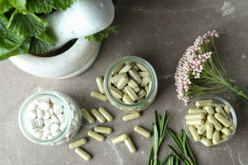 Concept of herbal medicine pills on gray textured background